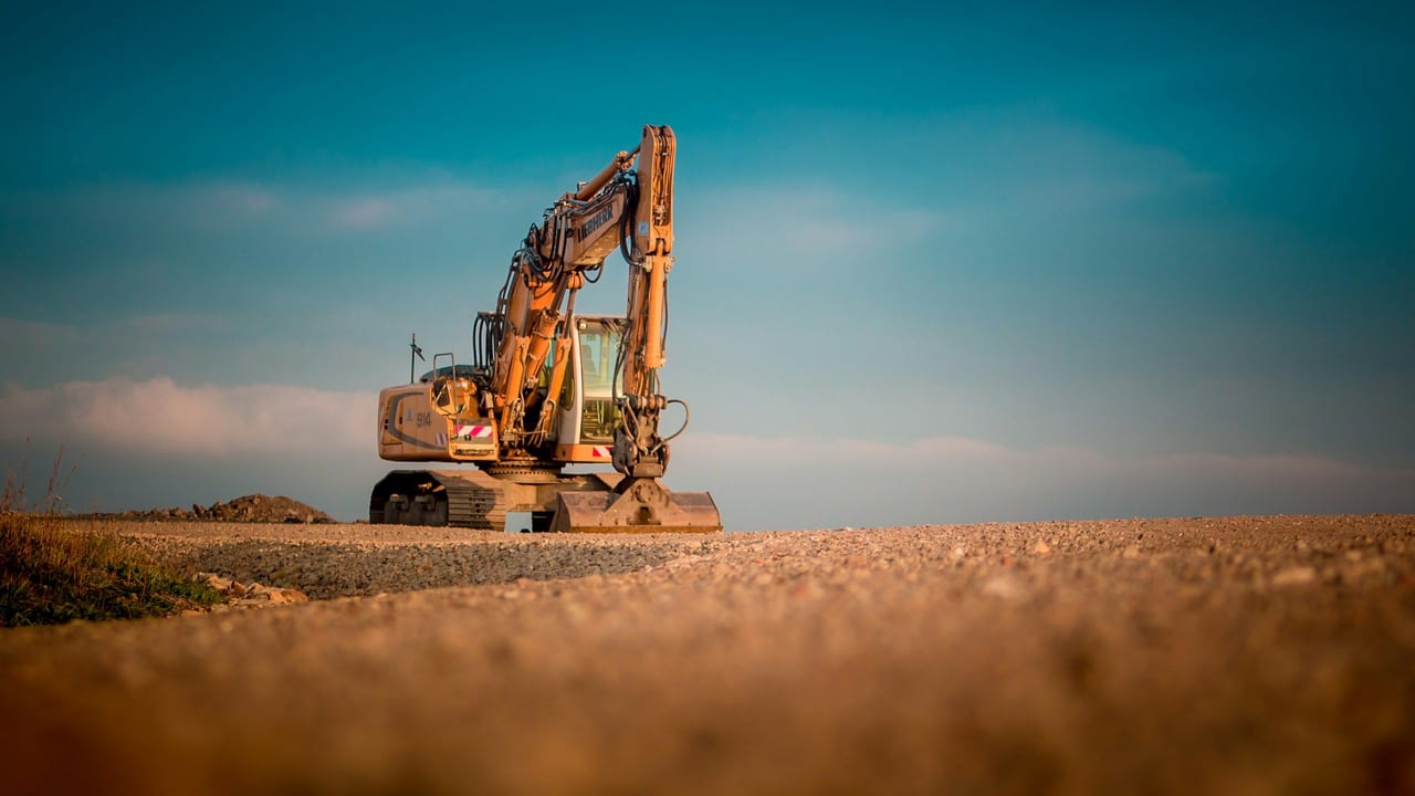 Excavadora amarilla en una obra bajo un cielo despejado
