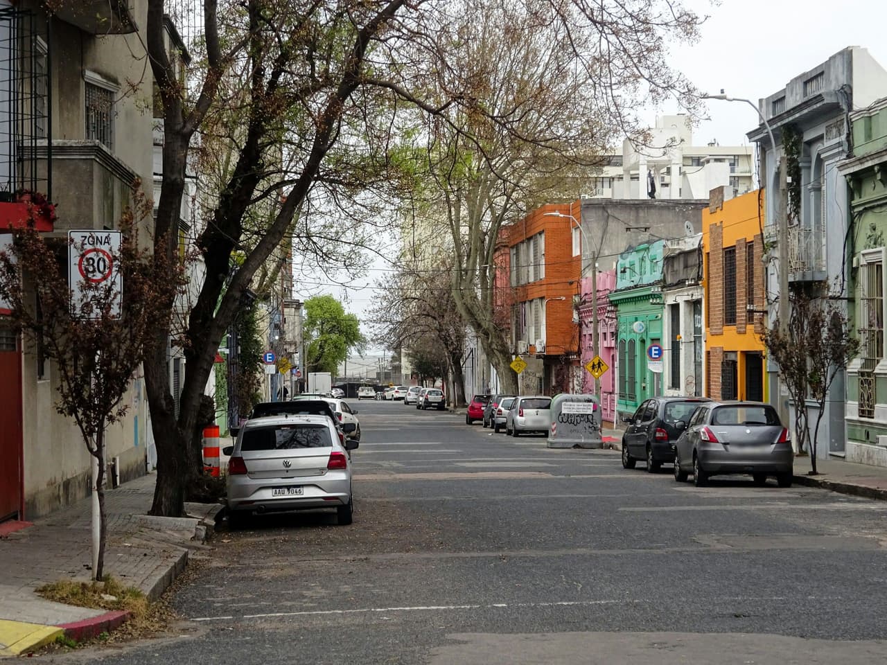 Calle de una ciudad latinoamericana con carros estacionados